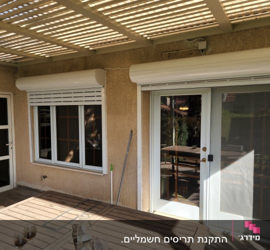 תריסי אלומיניום לבנים על חלונות ודלתות זכוכית